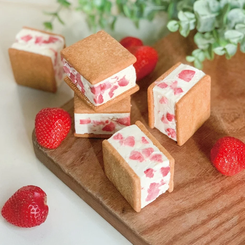 いちごが散りばめられたクリームが挟まれたクッキーサンド