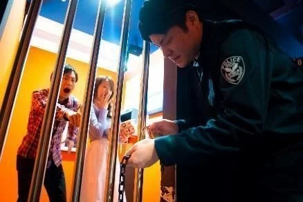 牢屋に閉じ込められた男女と警察官