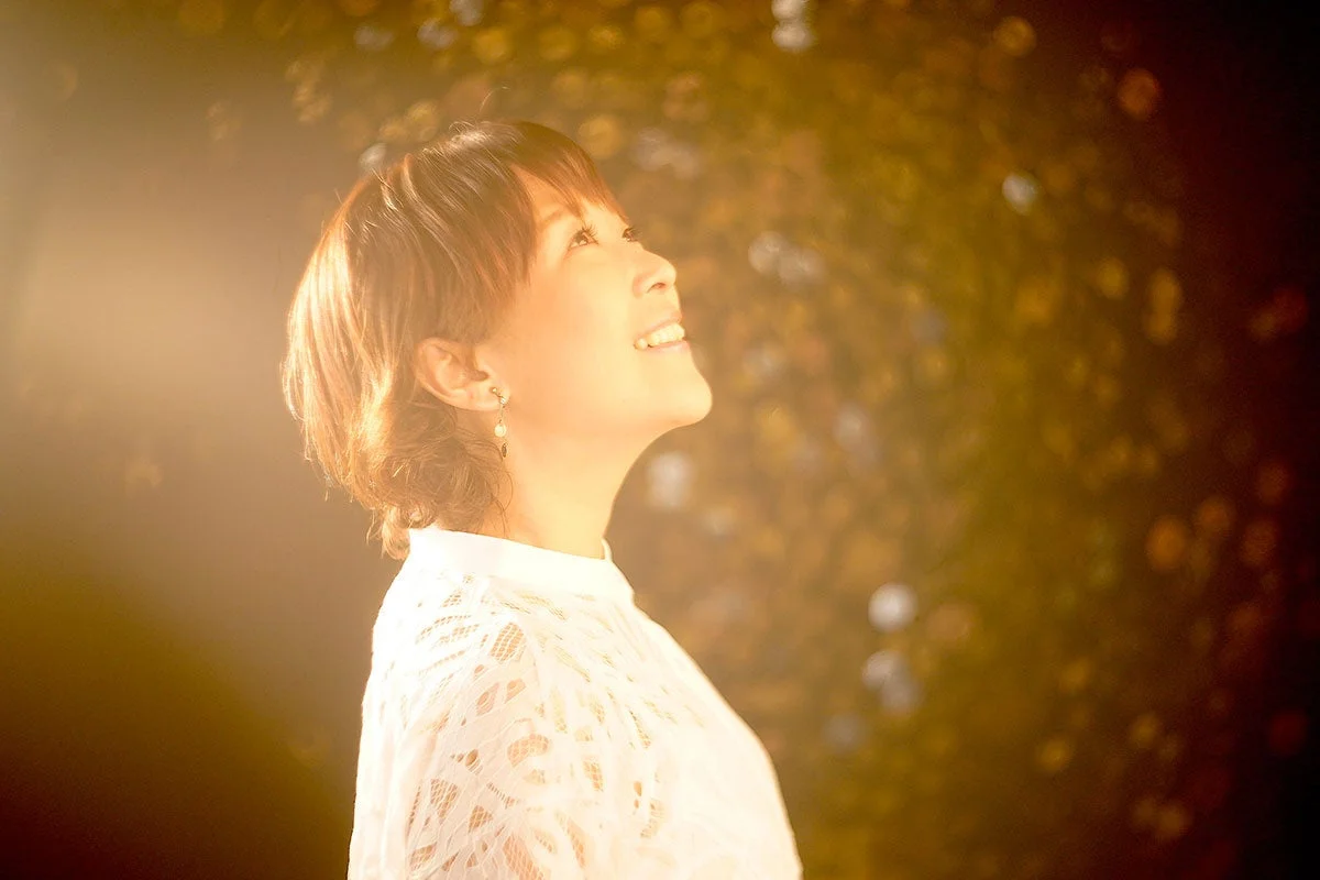 温かい逆光の中で白いレースの服を着た女性のポートレート