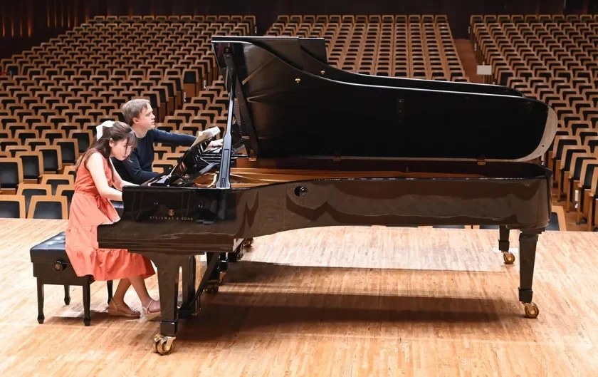 グランドピアノを連弾する2人