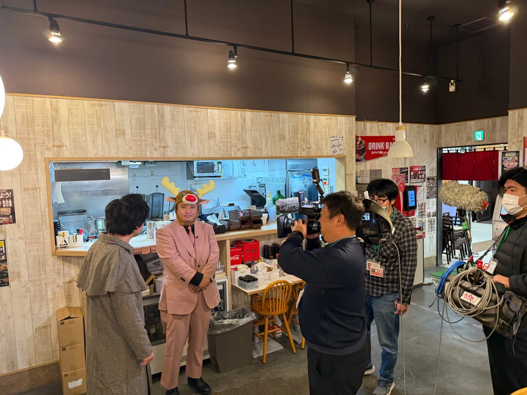 飲食店のような場所でカメラクルーに撮影されている様子