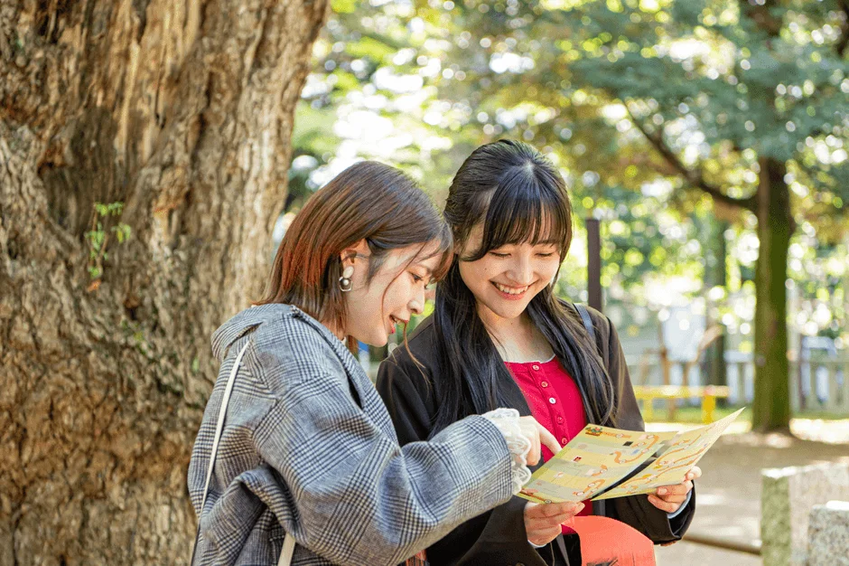 笑顔で地図を広げる二人の女性