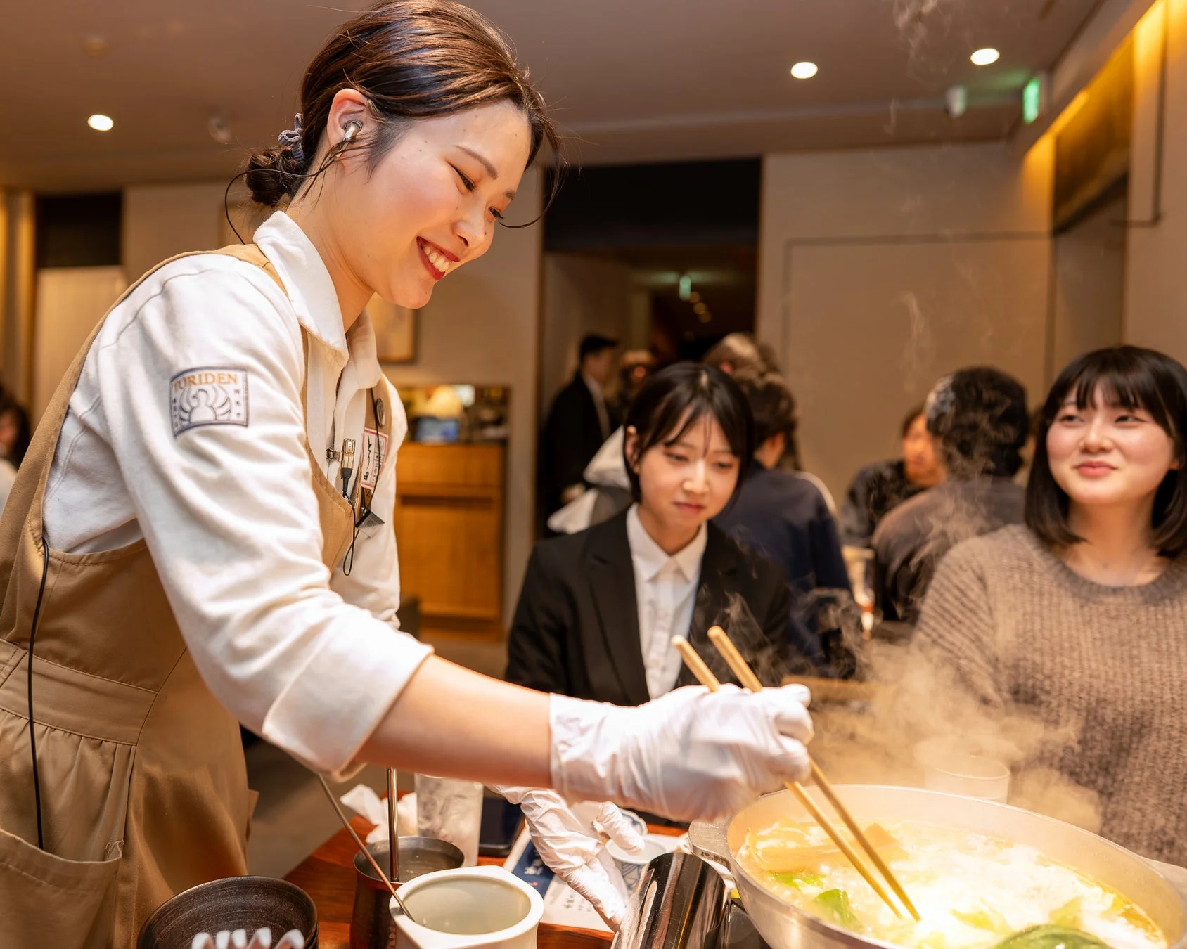 笑顔で鍋を取り分ける店員
