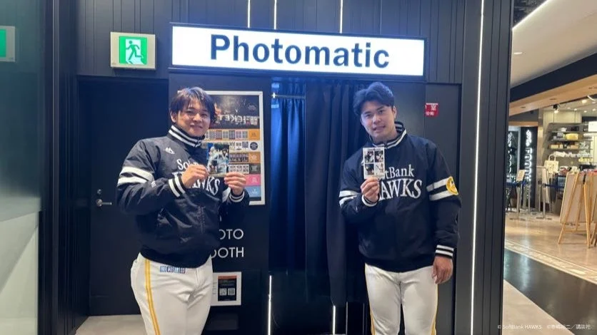 撮影された写真を持つ松本晴投手と谷川原選手