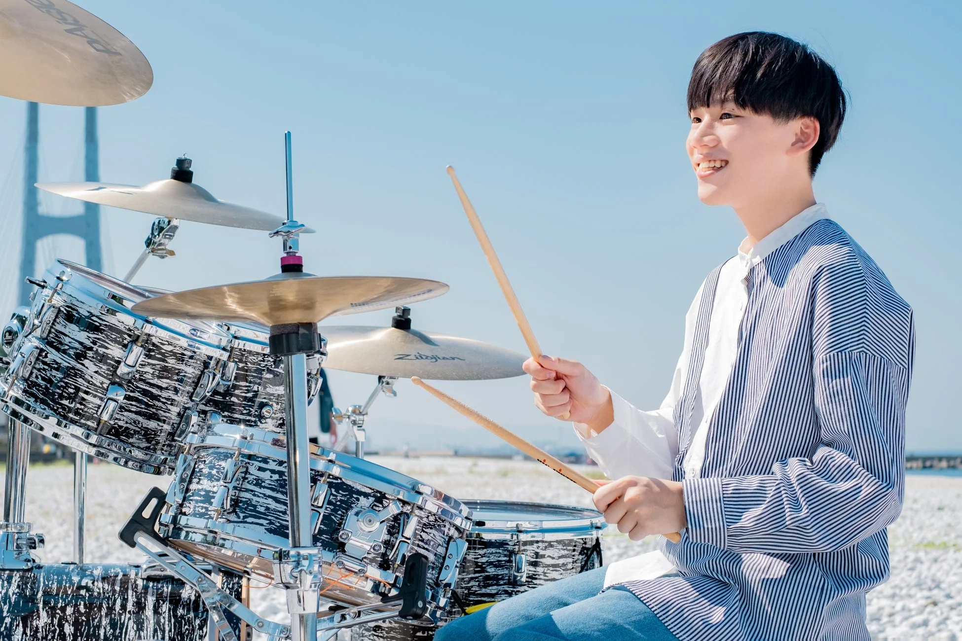 屋外でドラムを演奏する若者