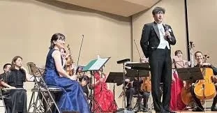 クラシックコンサートの舞台で話す木村厚太郎氏とオーケストラ
