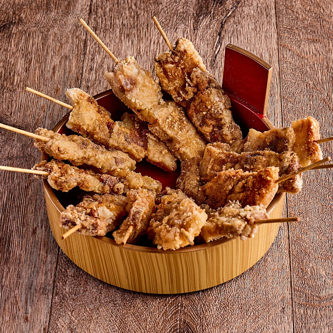 木製の器に盛り付けられた、たくさんの揚げ物の串