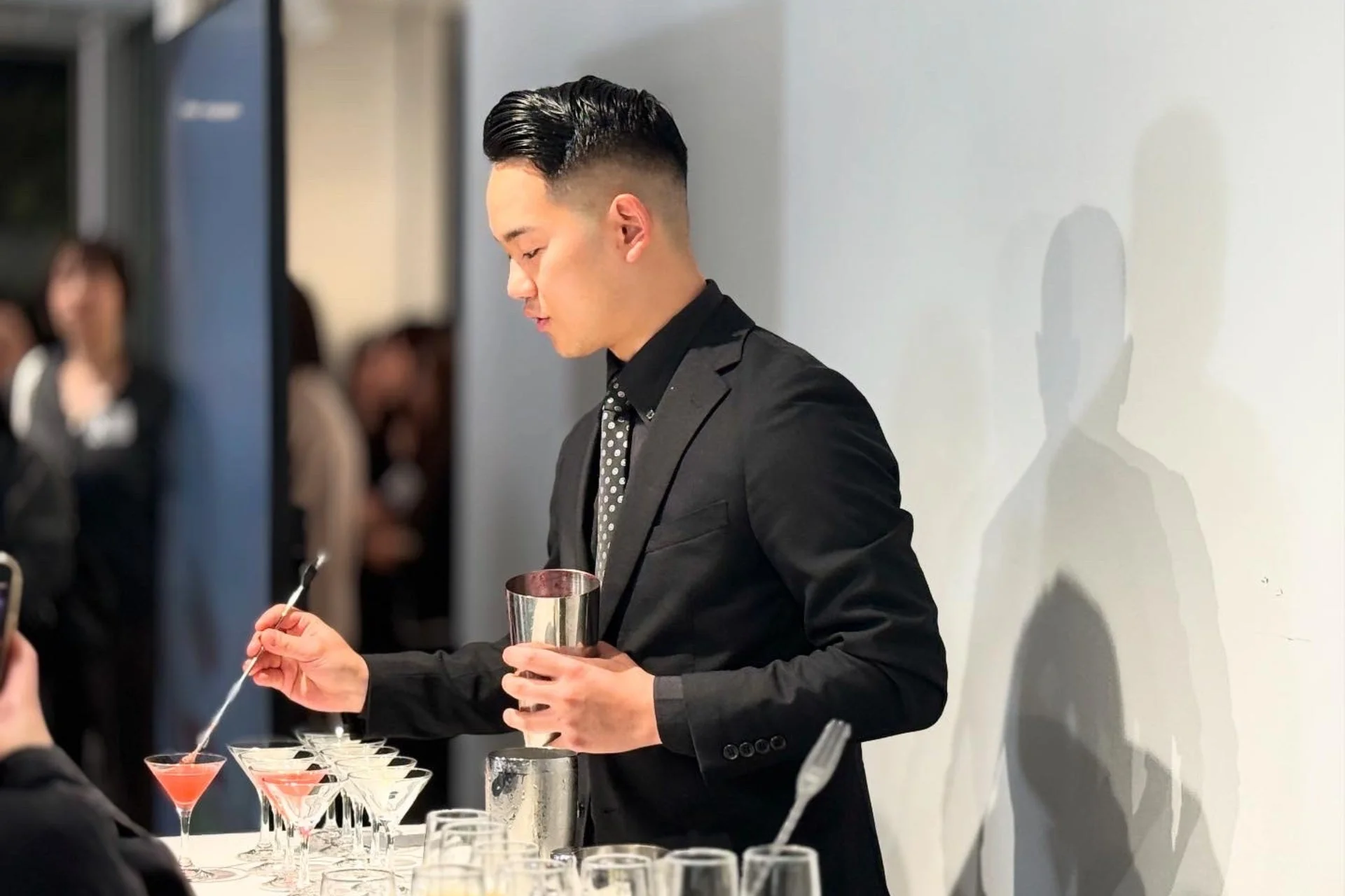 スーツを着た男性がカクテルを準備している様子