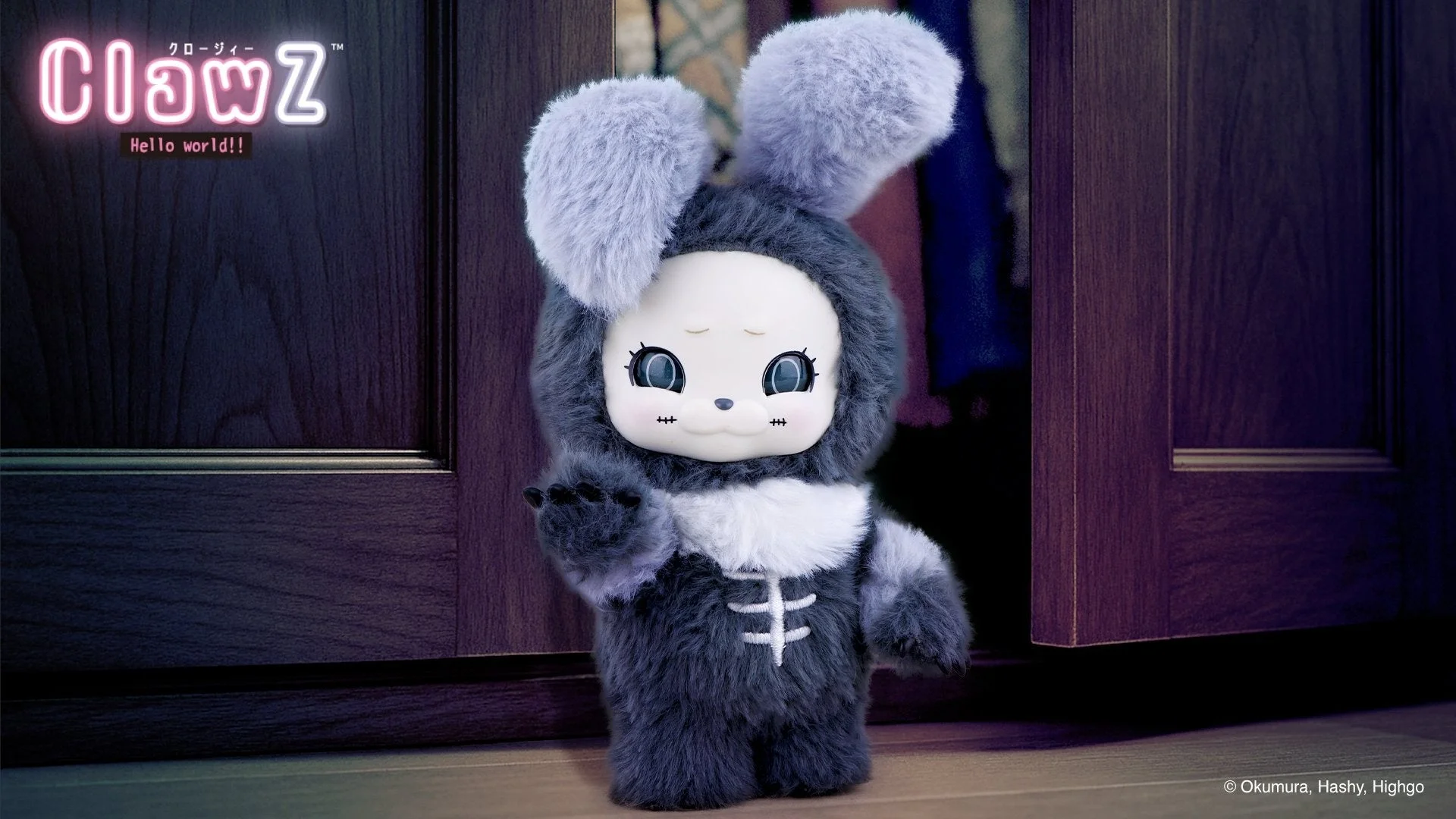 暗い木製のドアの前に立つ、ふわふわのグレーの毛並みを持つウサギのようなキャラクターのぬいぐるみ