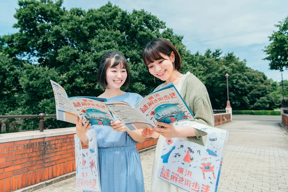 横浜謎解き街歩きガイドブックを見る女性