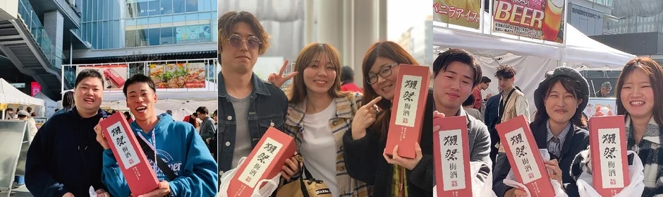 屋外イベントで、楽しそうな若者たちが「獺祭梅酒」の赤い箱を持って笑顔でポーズをとっている