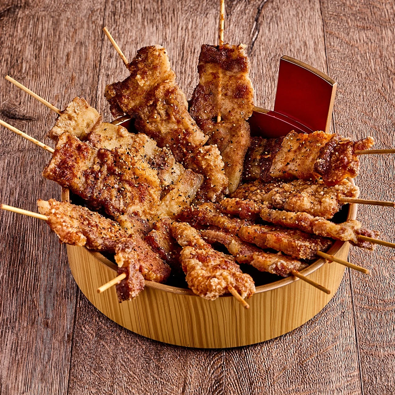 木製の器に盛り付けられた、香ばしく揚げられた様々な串焼き