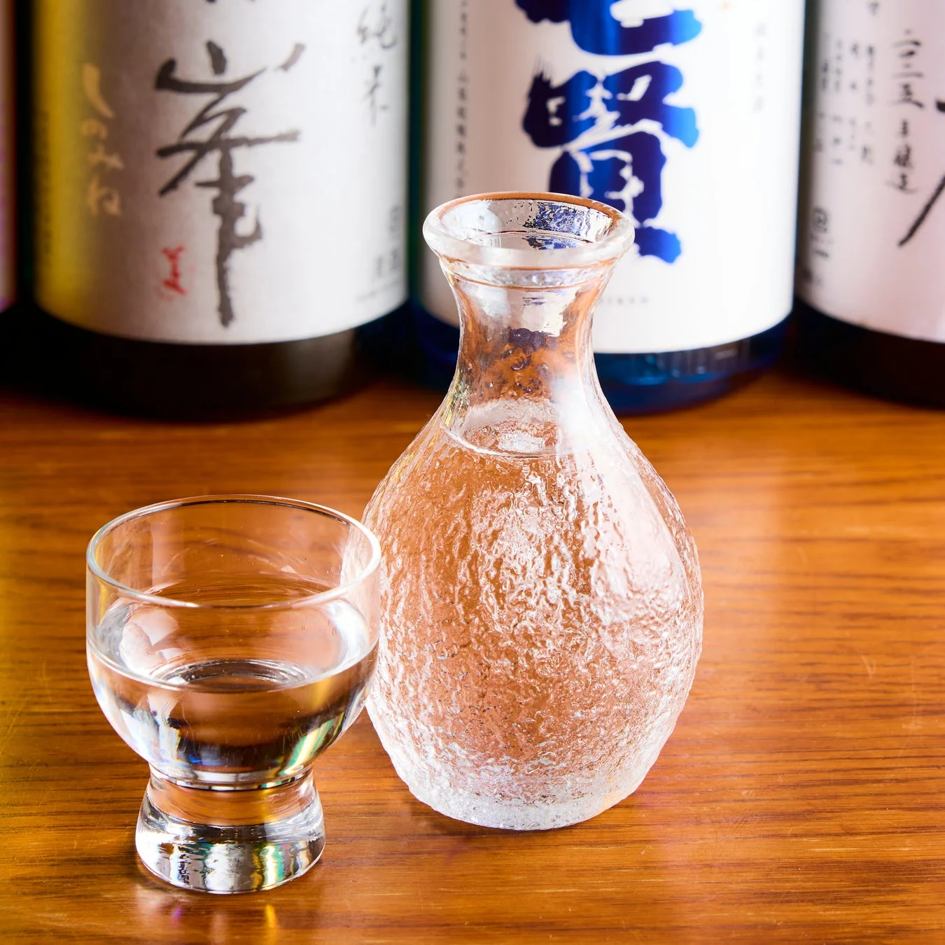 木製のテーブルに置かれた日本酒の入ったお猪口と徳利