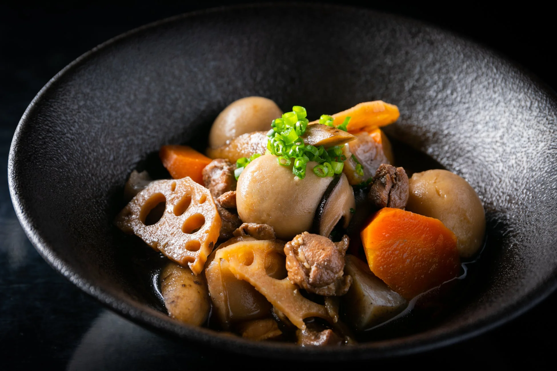 里芋、蓮根、人参、牛肉、しいたけなどの具材が煮込まれた和食の煮物