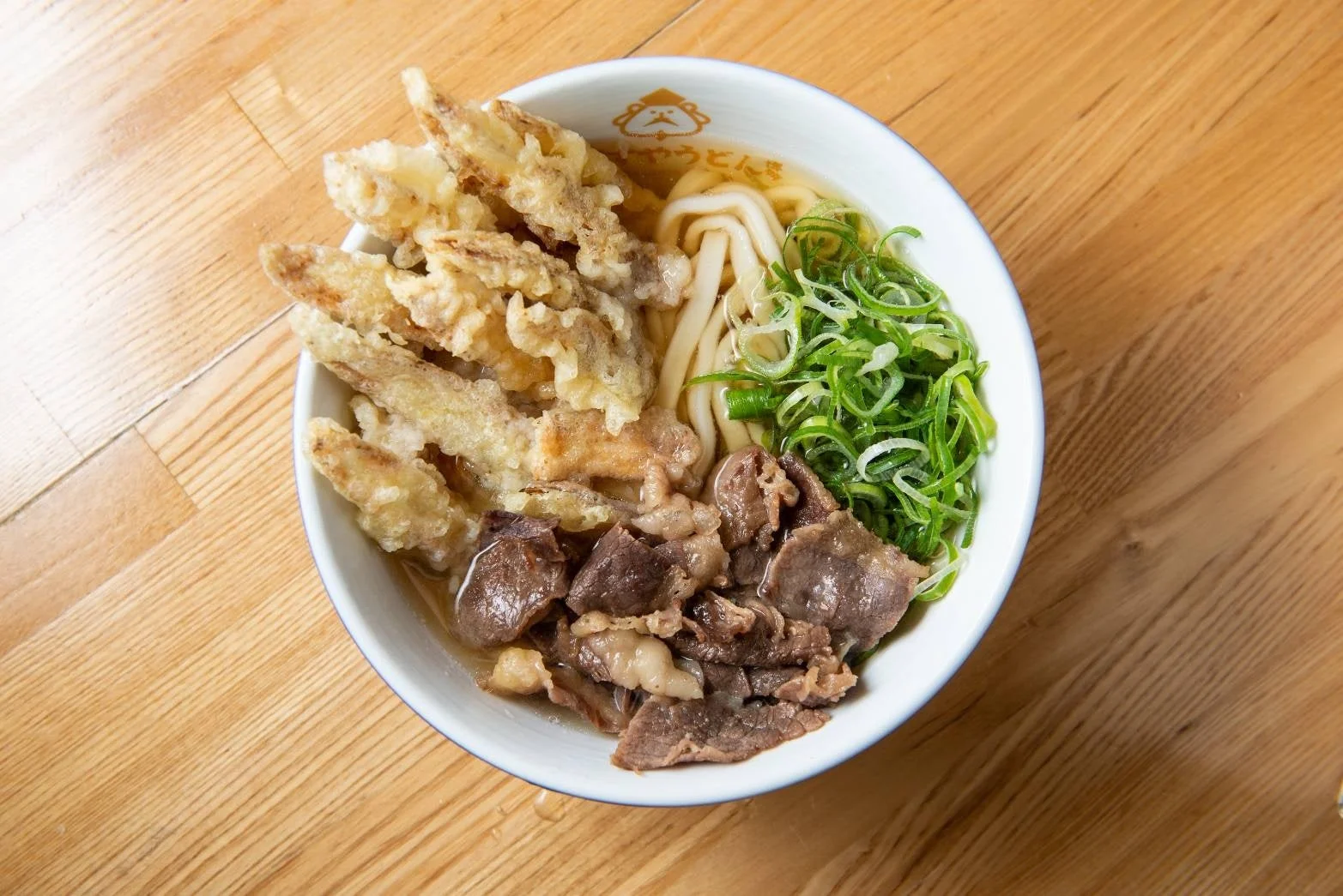 舞茸天ぷら、牛肉、たっぷりの刻みネギがトッピングされたうどん