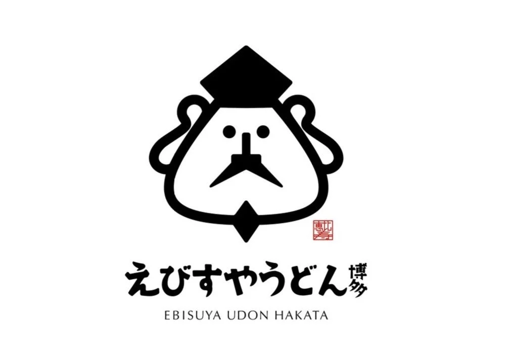 ひげを生やした特徴的な顔のキャラクターがデザインされた「えびすやうどん博多」のロゴ