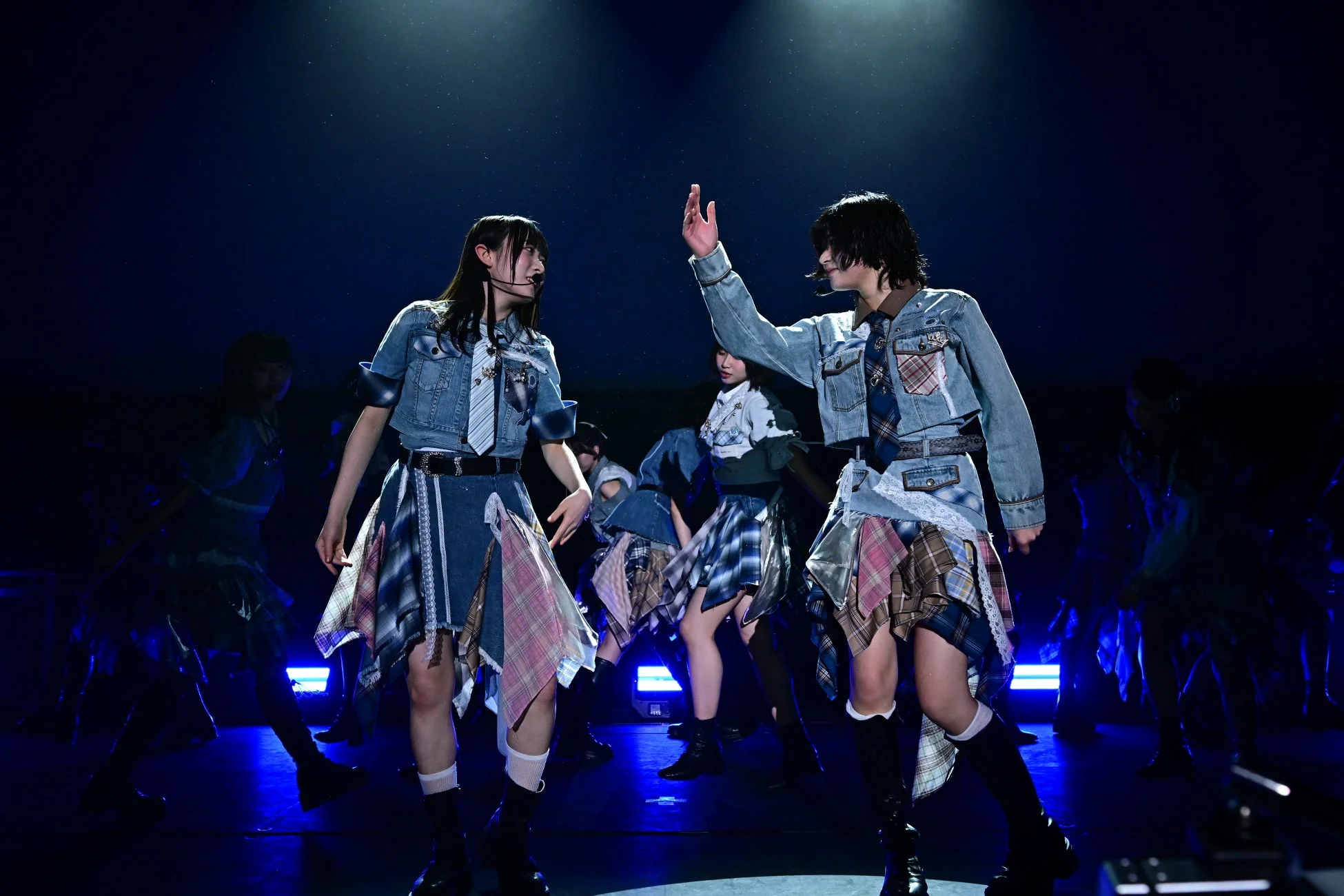 ライブステージでパフォーマンスするアイドルグループ