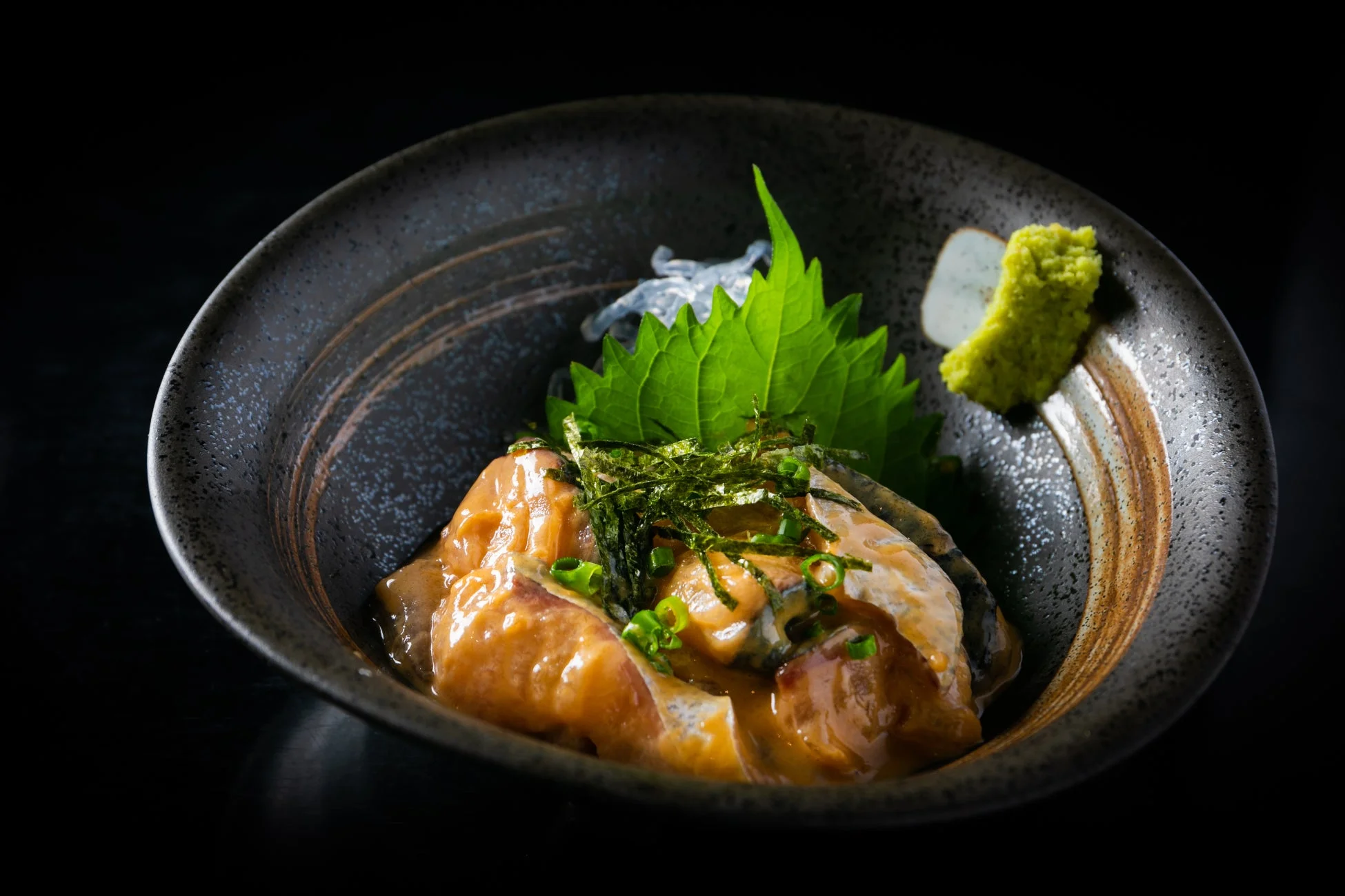 黒い器に盛り付けられた魚介の和え物