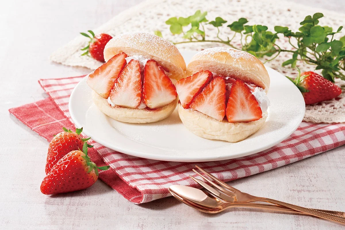 白い皿に盛られた2つのいちごサンドが主役の画像