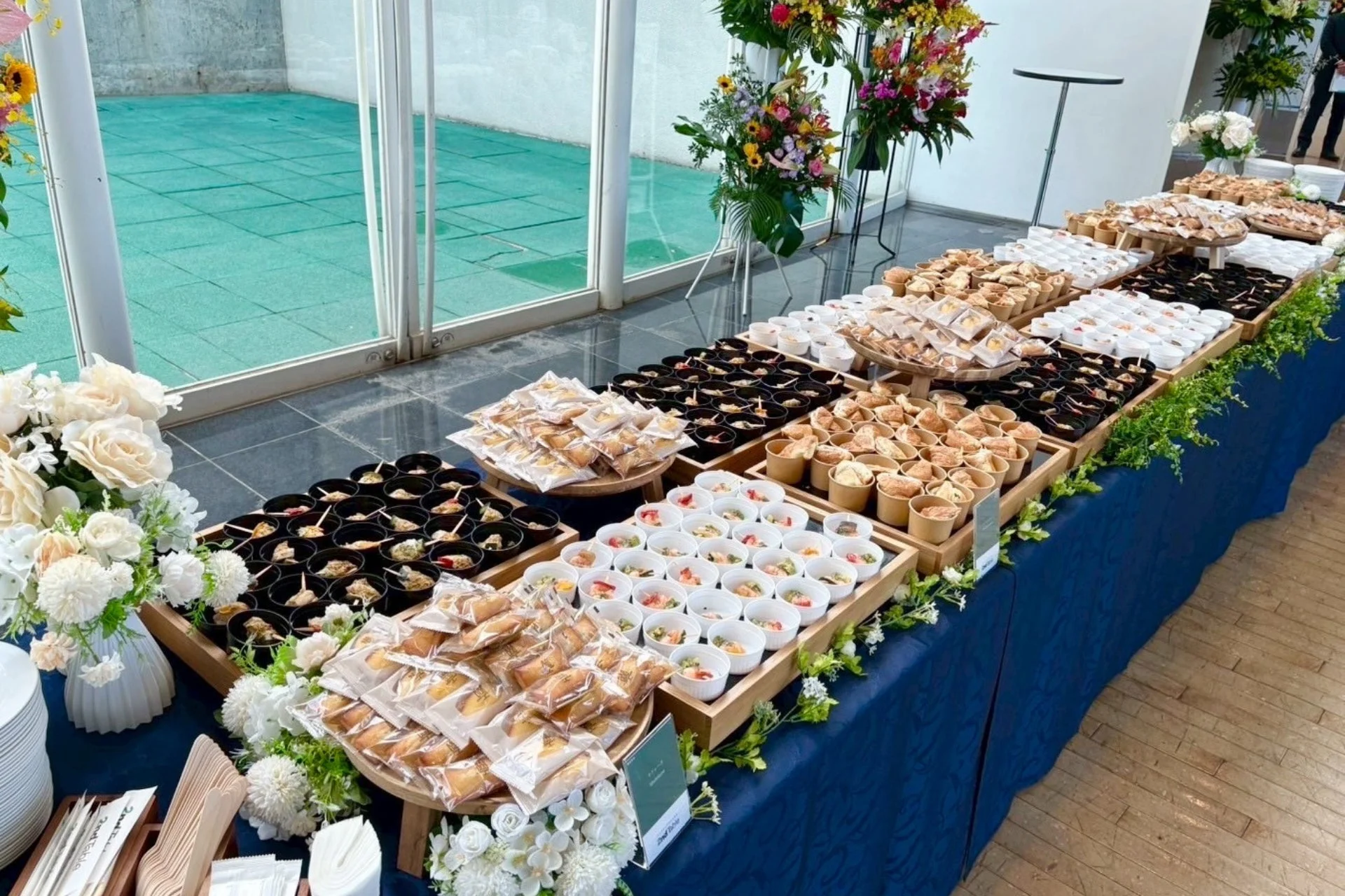華やかな花々で飾られたビュッフェ形式のオードブルとスイーツ