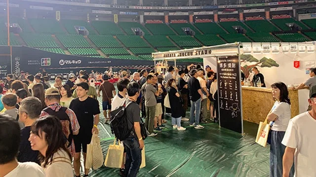 博多焼酎の屋台に並ぶ人々