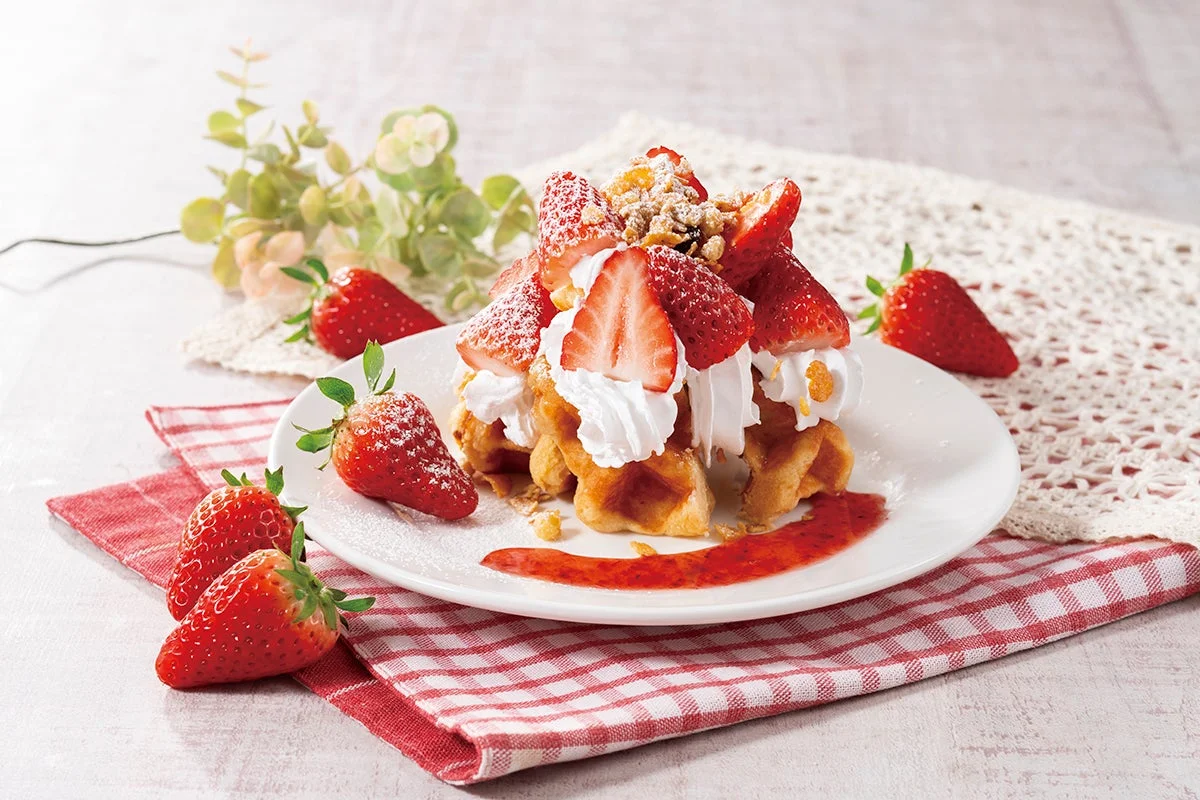 焼きたてのワッフルに、山盛りの新鮮ないちごとたっぷりのホイップクリームがトッピングされた豪華なデザート