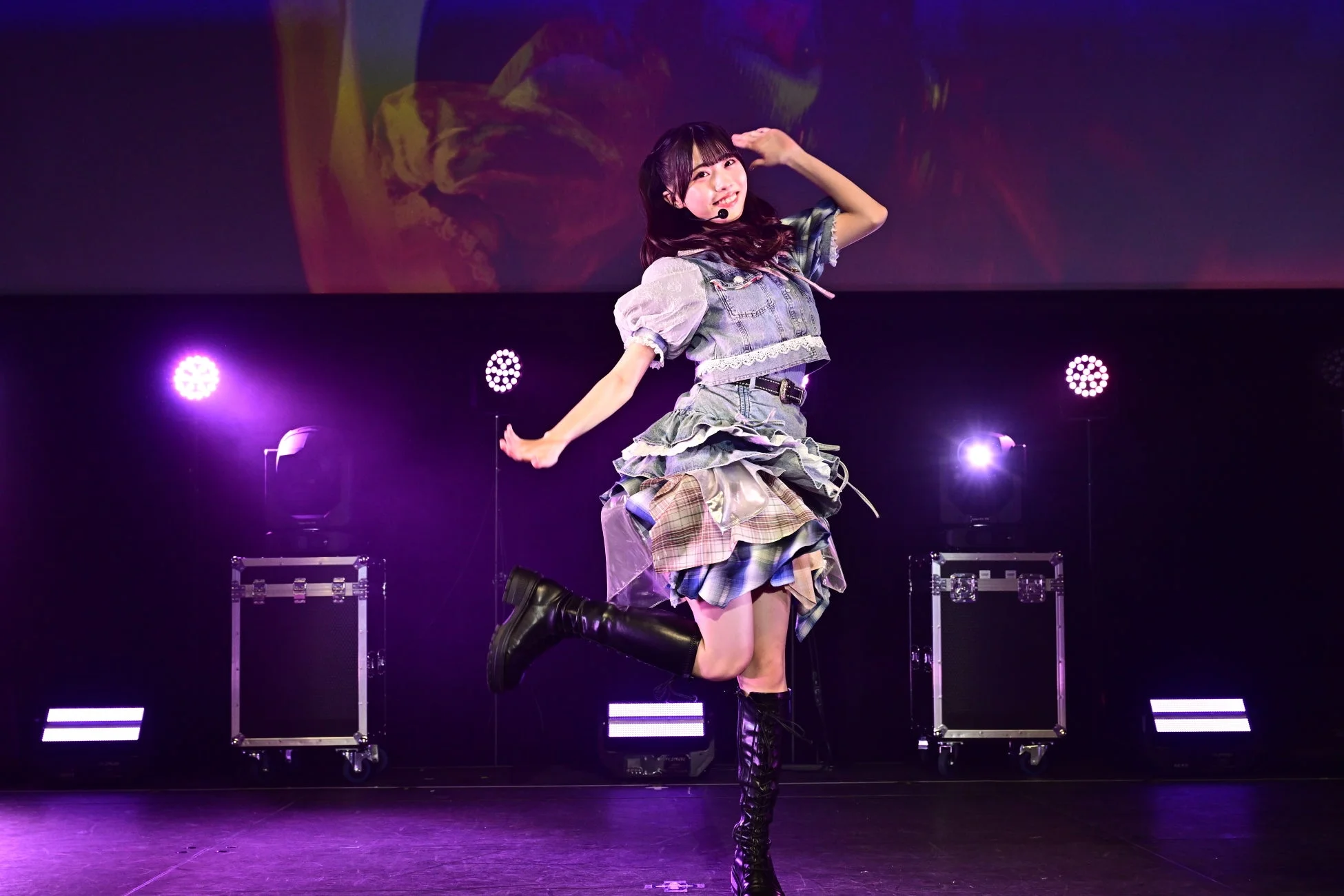 紫色の照明が照らすステージでパフォーマンスするメンバー