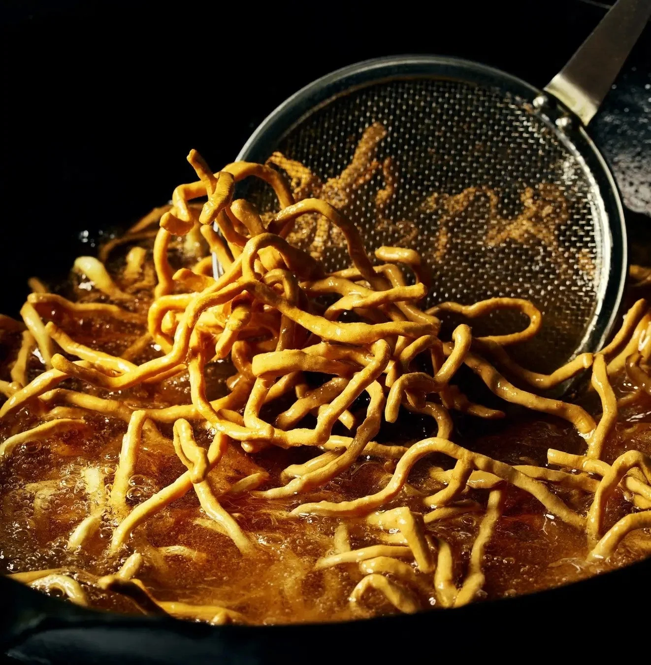 熱い油で揚げられている麺の様子