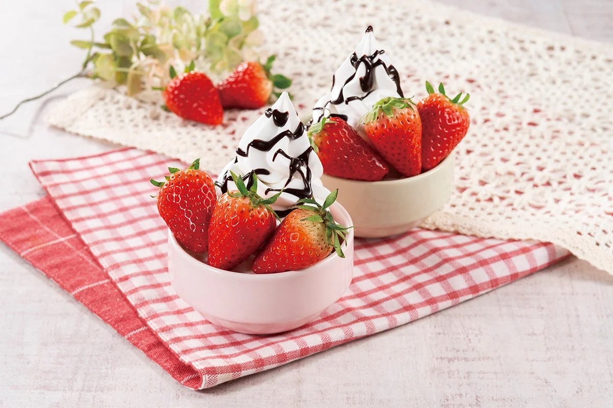 新鮮ないちごとチョコレートソースがかかったソフトクリームが小さな器に盛り付けられています