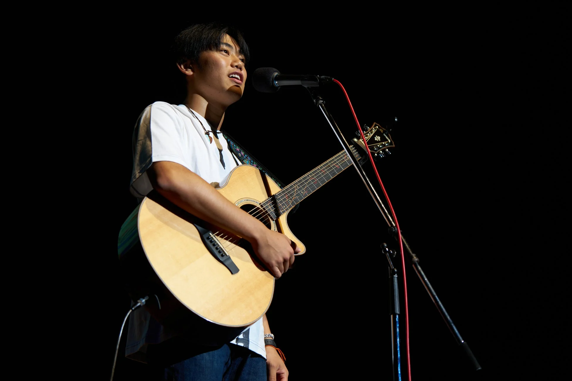 アコースティックギターを弾きながら歌う男性