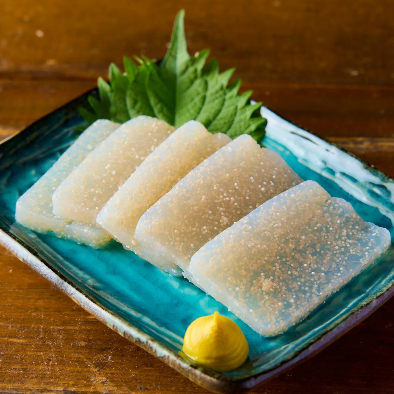 青い皿に盛り付けられた刺身こんにゃくの画像