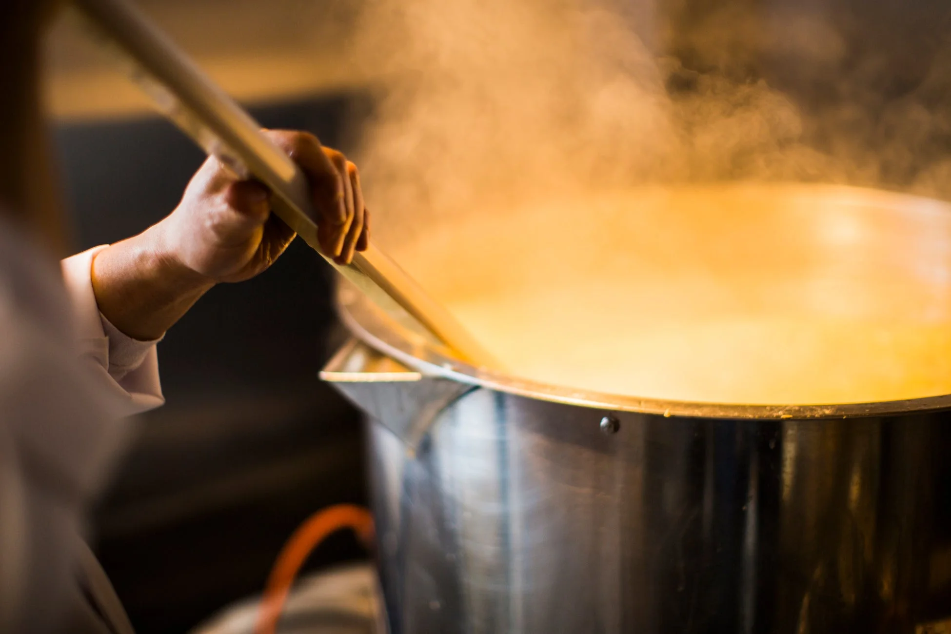 鍋をかき混ぜる料理人