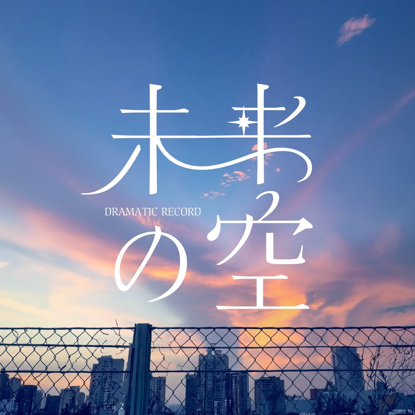 美しい夕焼け空を背景に、「未来の空 DRAMATIC RECORD」という文字が大きく配された画像です。手前にはフェンスと街並みのシルエットが見えます。
