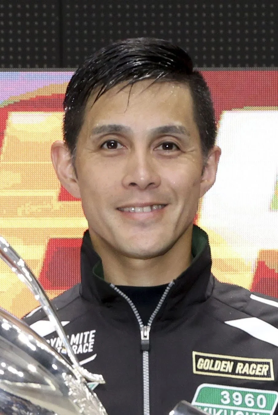 笑顔でトロフィーを持つ菊地孝平選手