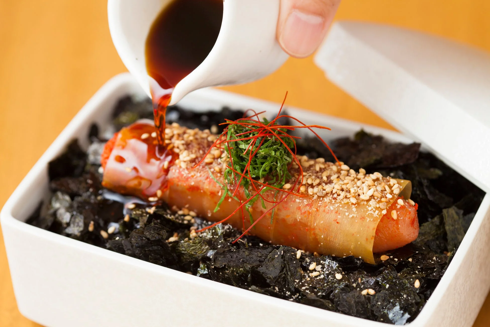 めんたい重にたれをかける様子