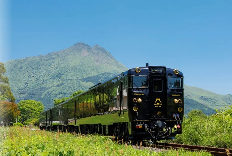観光列車「かんぱち・いちろく」が山々を背景に走行