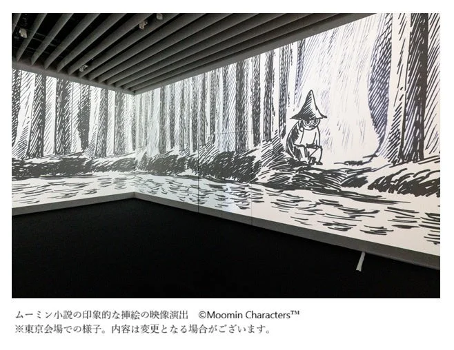 ムーミン小説の挿絵をモチーフにした、スナフキンが森と水辺にいるような白黒のイラストが壁一面に投影された映像演出の展示風景です。