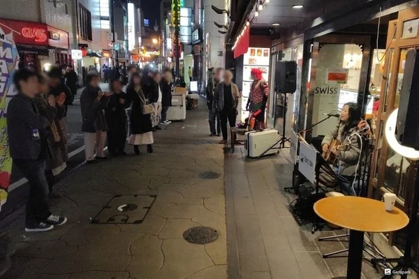 夜の繁華街でのストリートライブの様子