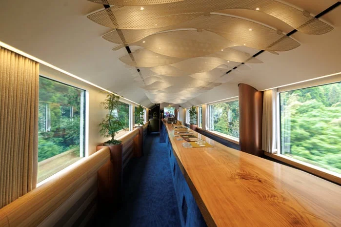 豪華な列車の内装、窓からは緑豊かな森の風景