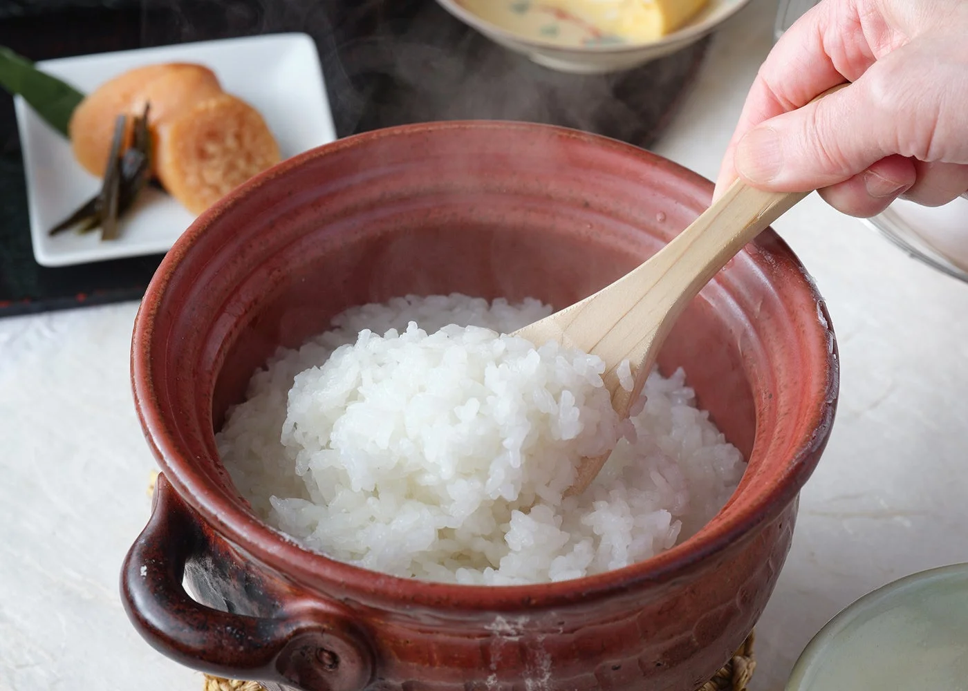 湯気が立ち上る土鍋で炊きたての白いご飯