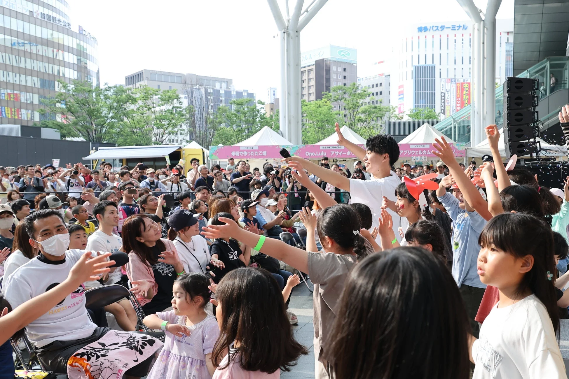 屋外イベントで手を振って楽しむ人々