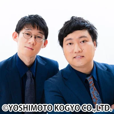 紺色のスーツを着用したお笑い芸人