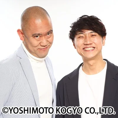 白い背景の前でポーズをとるお笑い芸人
