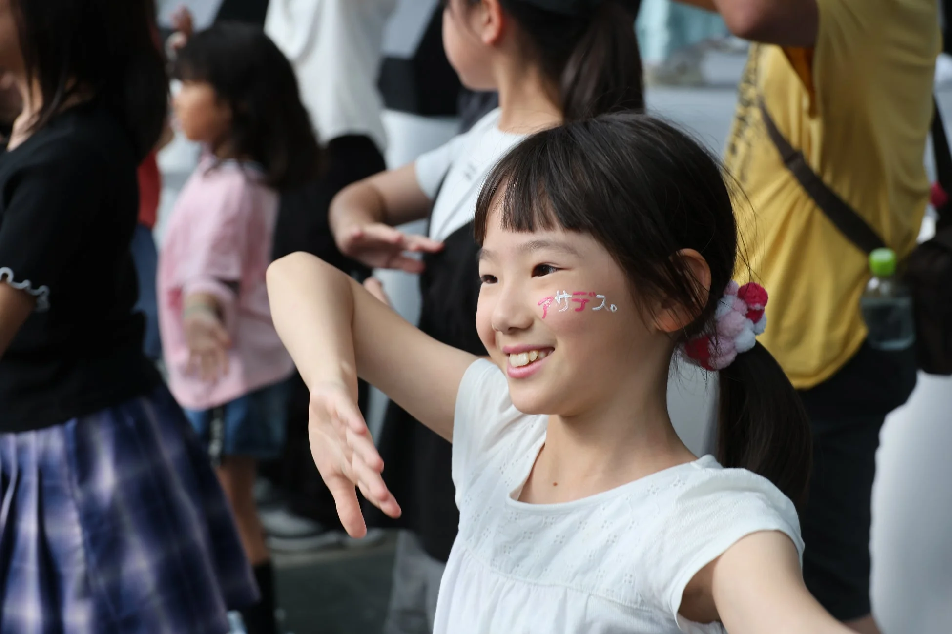 「アサデス。」とフェイスペイントを施した日本の少女