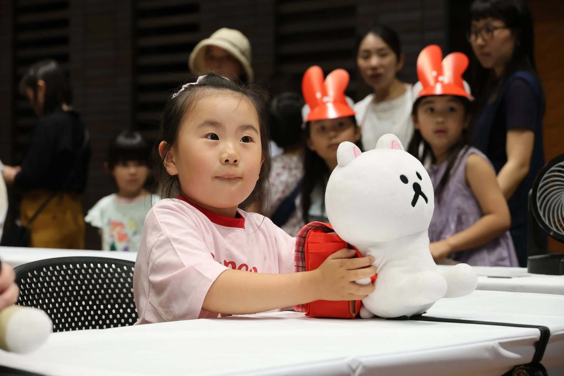 ぬいぐるみを抱えた女の子がイベントを楽しむ様子