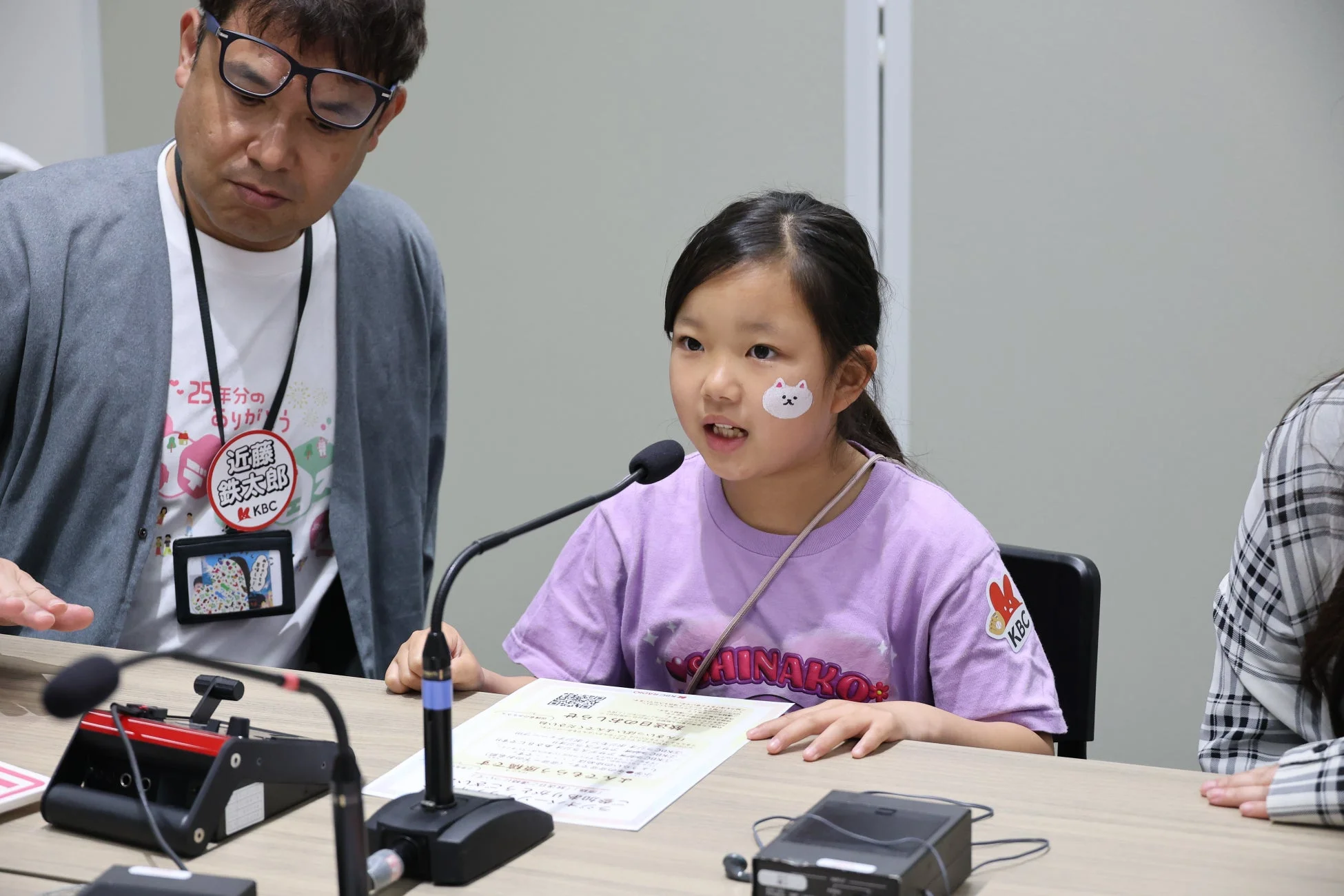 マイクに向かって話す少女と男性