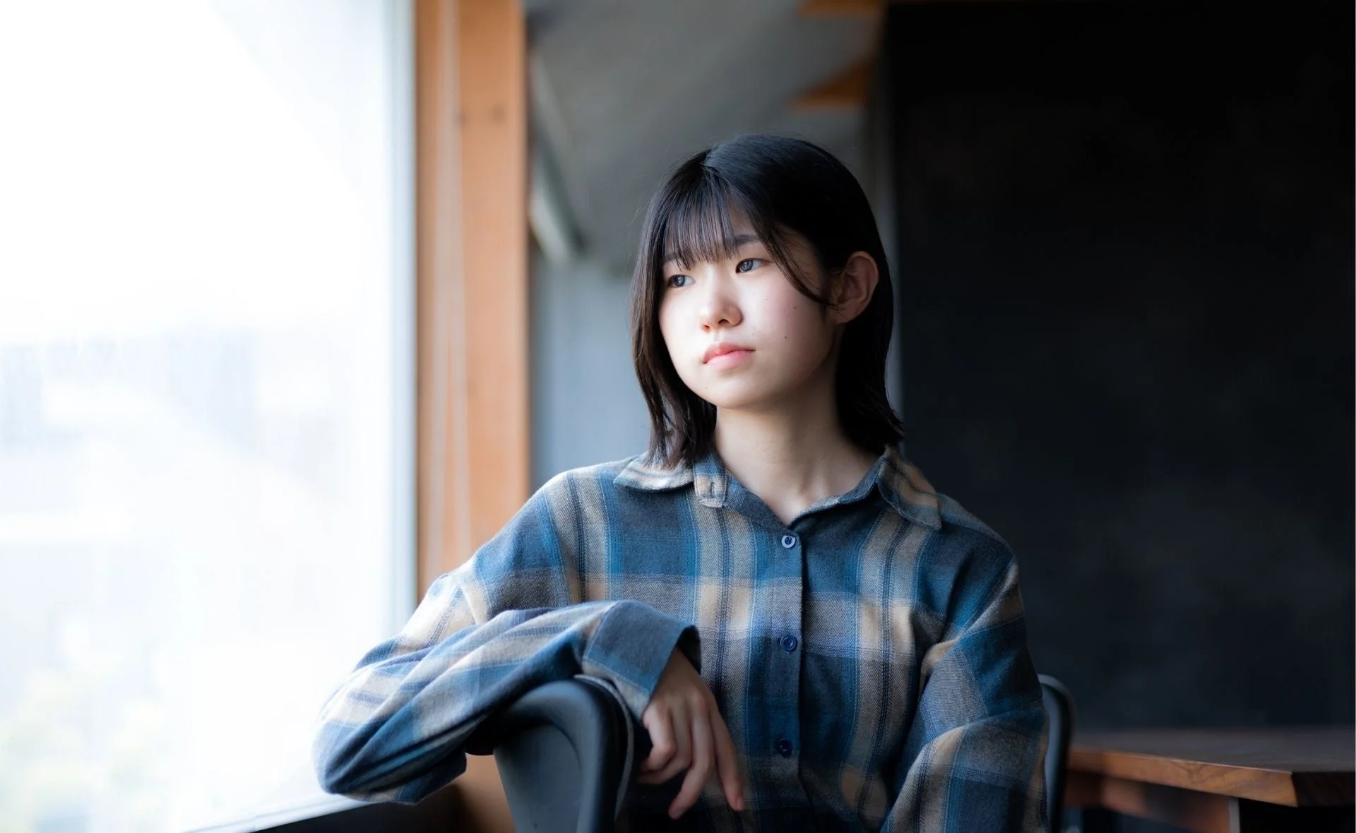 窓辺に座り外を眺めるShio氏