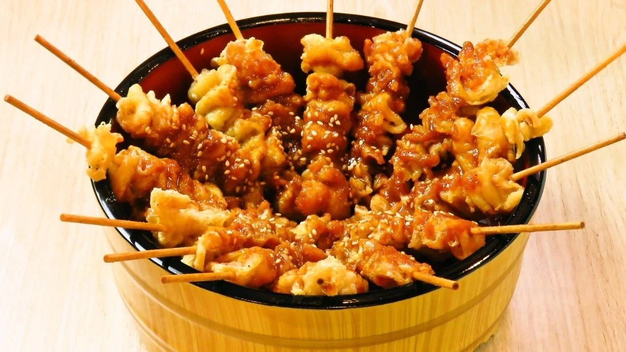 照り焼きソースとごまがたっぷりかかった鶏肉の串焼き