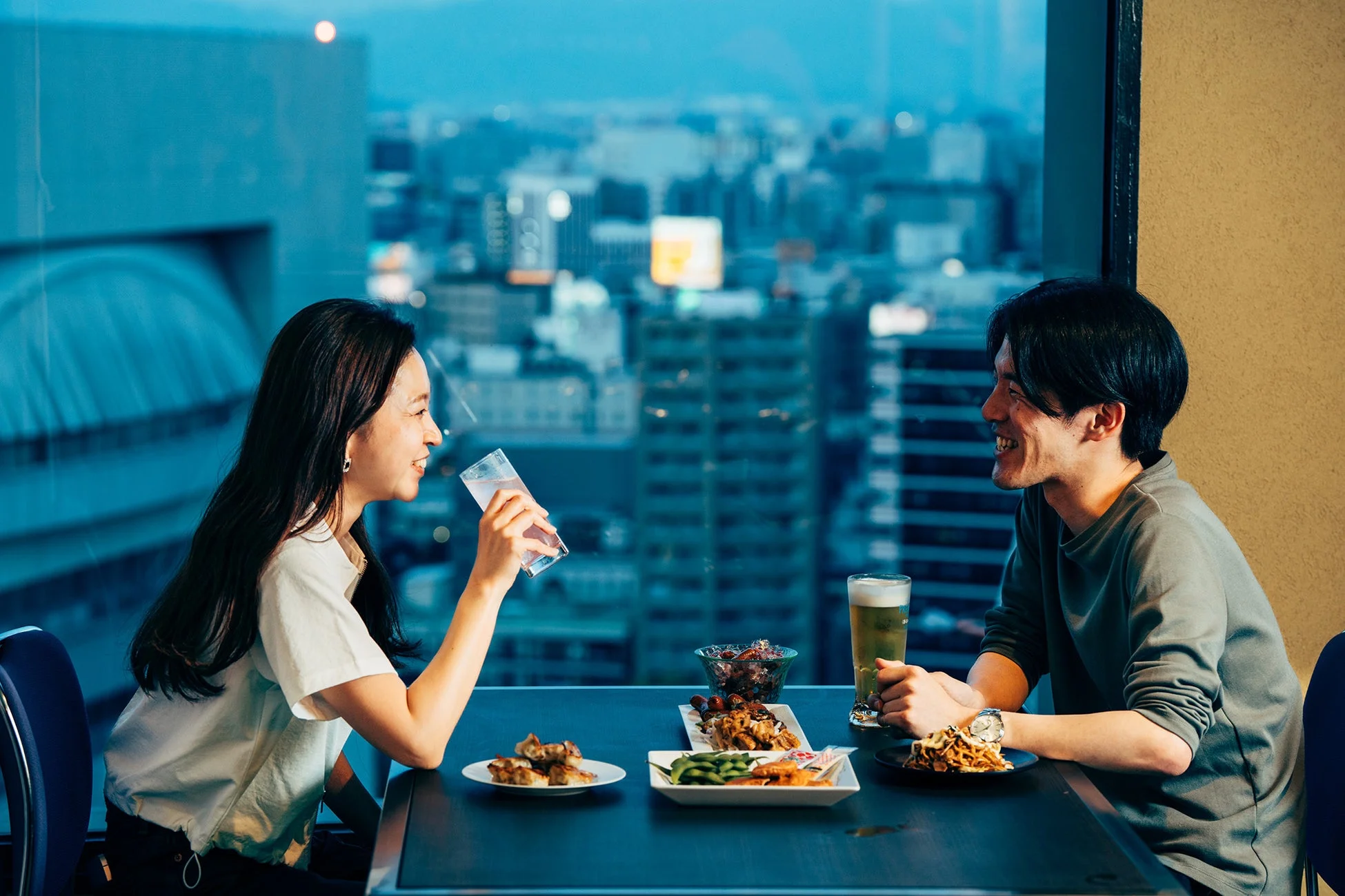 夜景を背景に食事を楽しむカップル