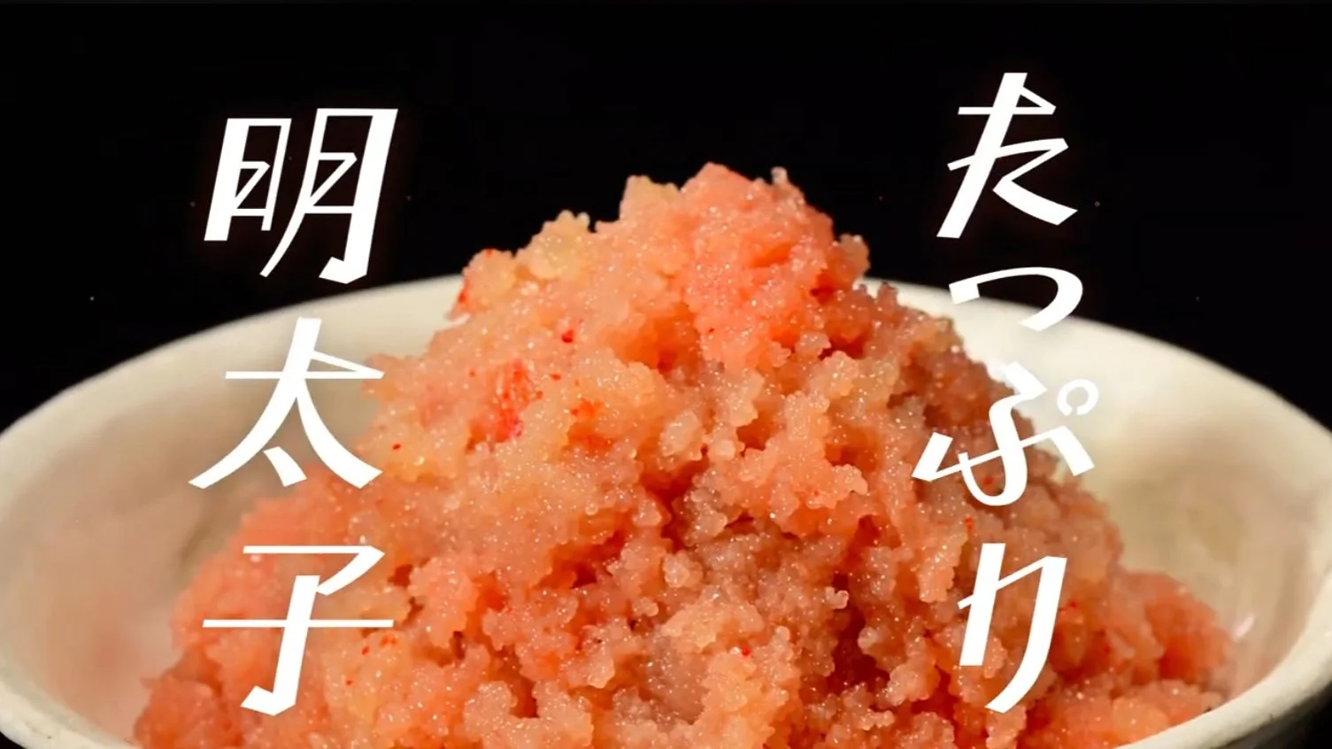 黒い背景に白い器に盛られた、粒立ちの良いピンク色の明太子がたっぷりと写っています。画面には「明太子たっぷり」という文字が大きく表示され、その豊富さを強調しています。